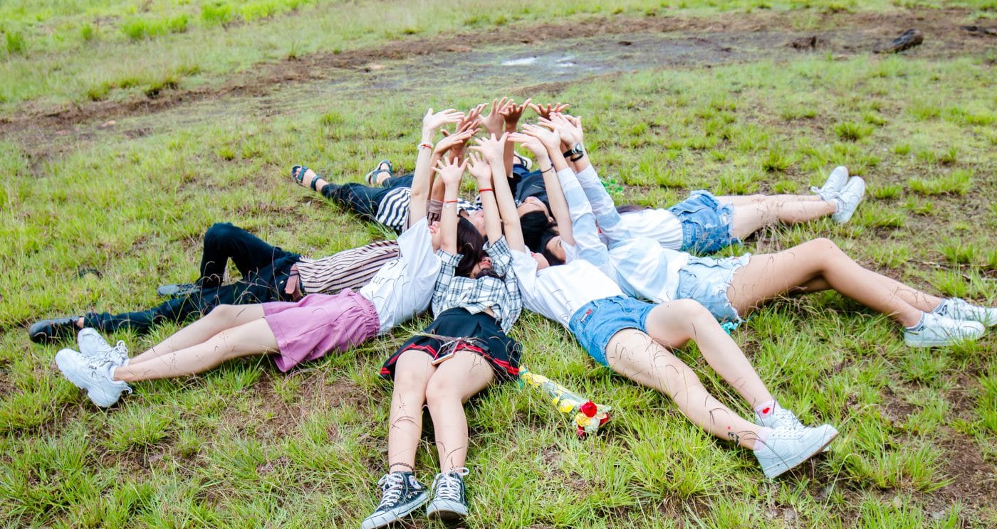 Group of people lying on the floor with their arms in the air